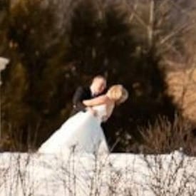 Groom dipping his bride outdoors in winter.