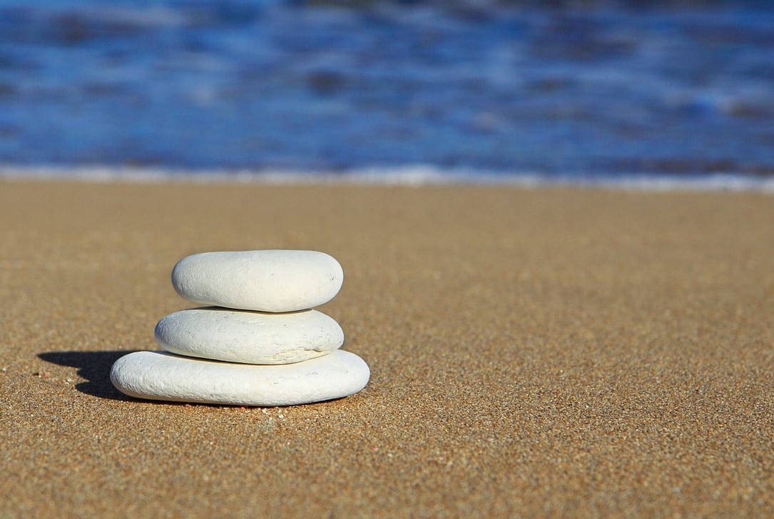 three smooth stacked stones on a beach