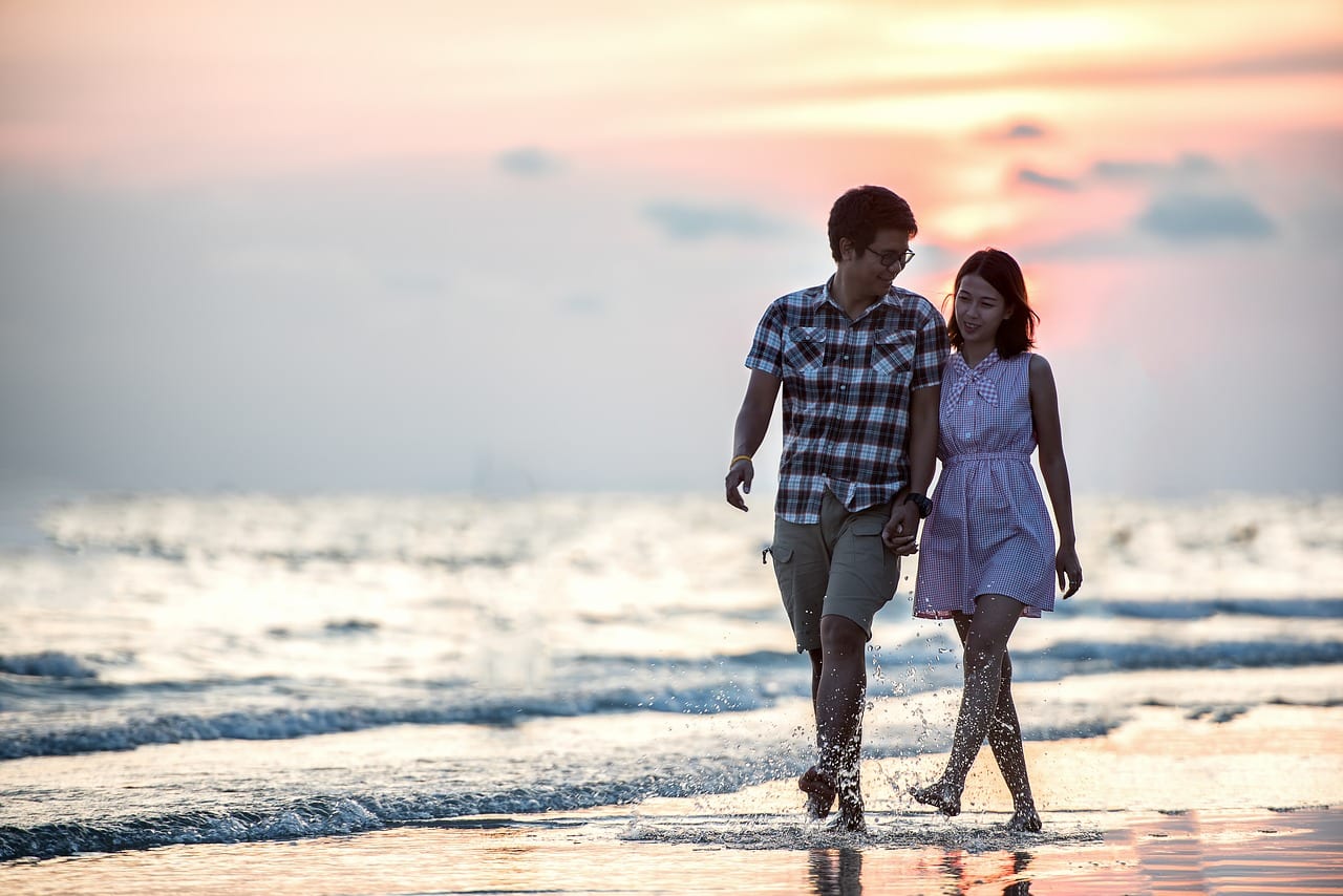 Couple walking along a beach shore
