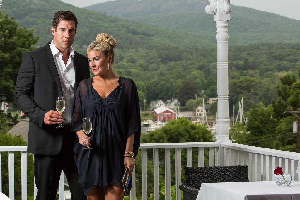 Couple on balcony holding wine glasses