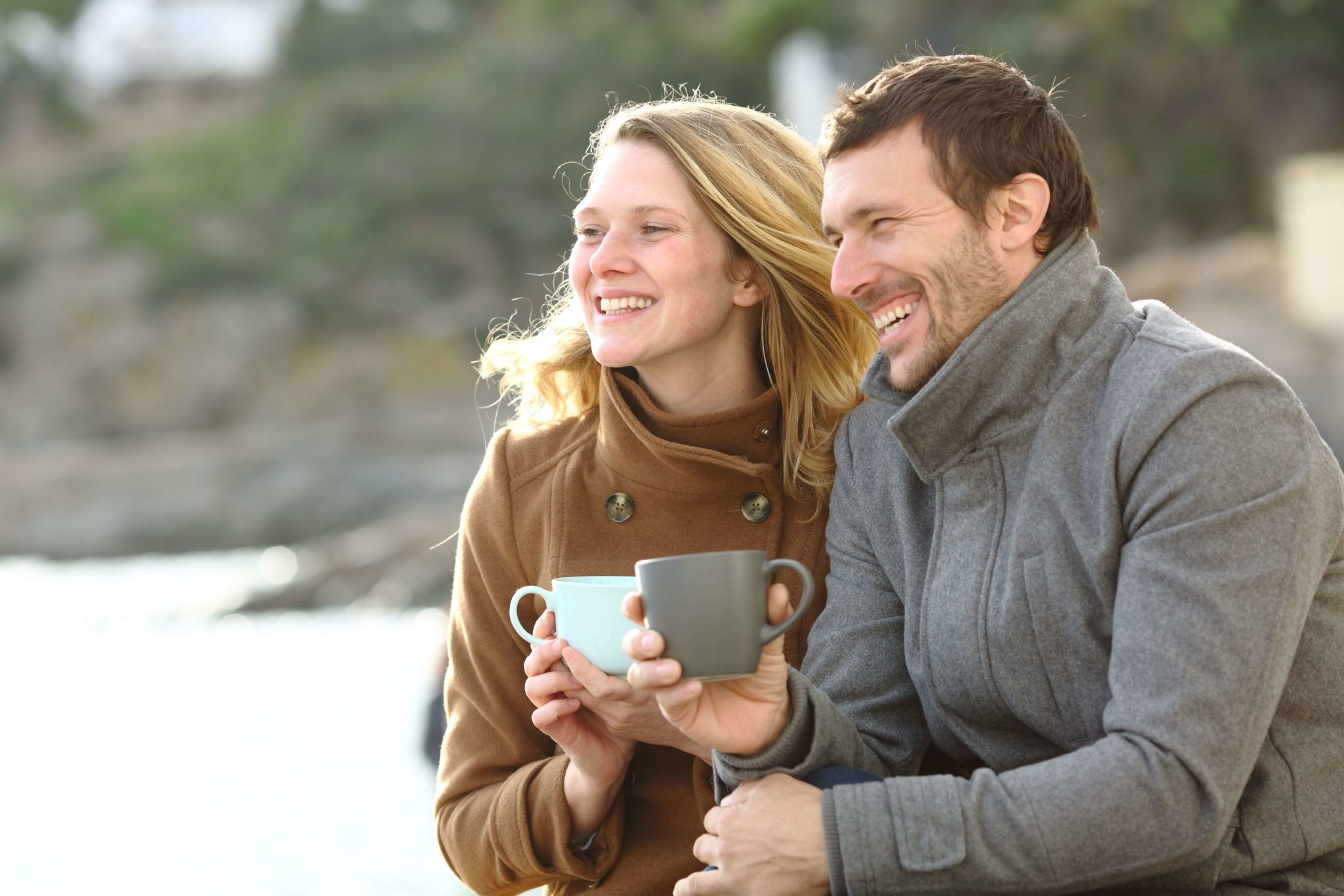 A man and a woman drinking coffee. One of the many things to do in Camden, Maine, for couples this fall.