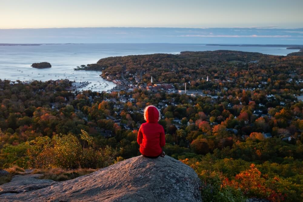 A person hiking at a Maine park in fall.